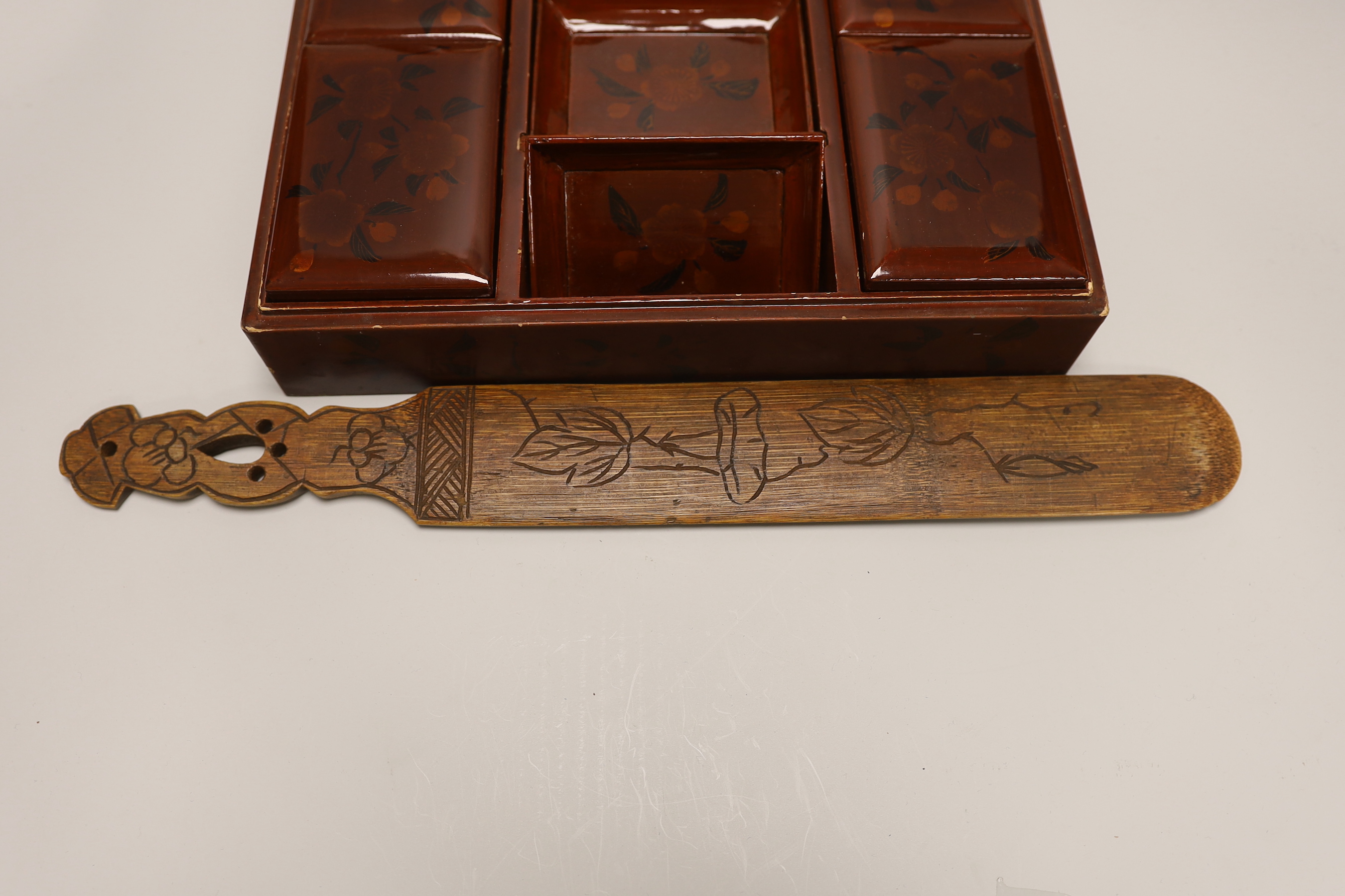 A Japanese lacquer games box, the cover having a central landscape painting together with a carved bamboo page turner, box 30 cm wide x 24 deep